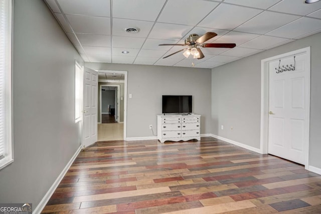 spare room with baseboards, ceiling fan, visible vents, and wood finished floors