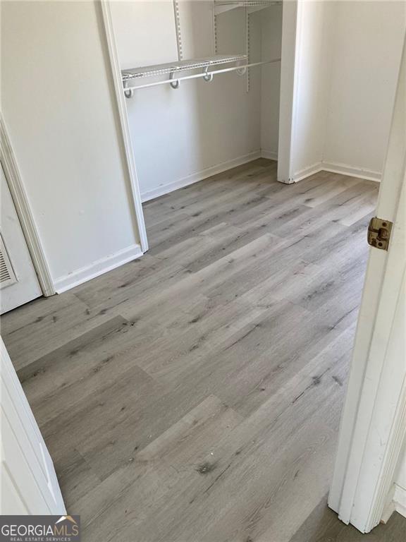 unfurnished bedroom with baseboards, a closet, and wood finished floors
