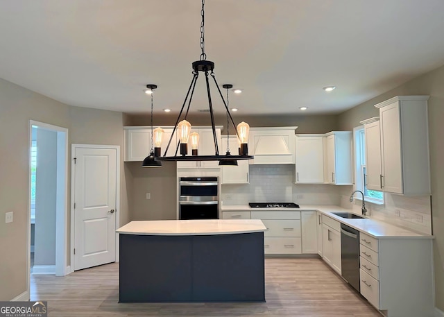 106 Canter Ct, Savannah, GA 31406 - kitchen with light wood-style flooring, a notable chandelier, a sink, appliances with stainless steel finishes, and decorative backsplash