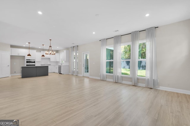 106 Canter Ct, Savannah, GA 31406 - unfurnished living room featuring recessed lighting, light wood finished floors, and a notable chandelier