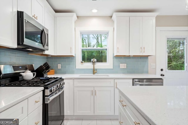 kitchen with a wealth of natural light, a sink, stainless steel appliances, and light countertops