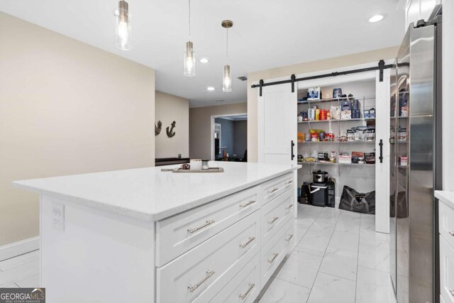 walk in closet featuring a barn door, a sink, and marble finish floor