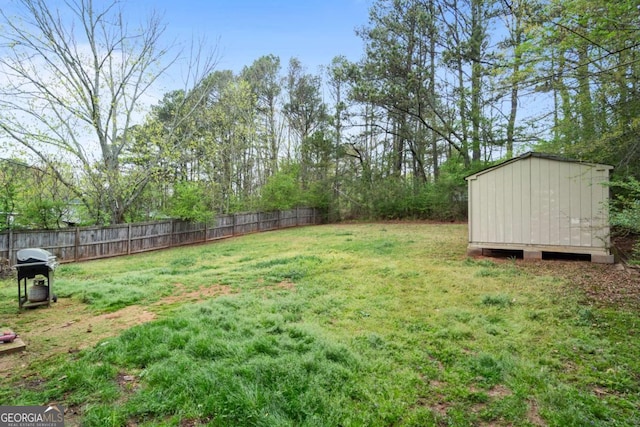 view of yard featuring an outdoor structure, fence, and a storage shed