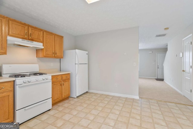 kitchen with light countertops, visible vents, white appliances, light floors, and under cabinet range hood