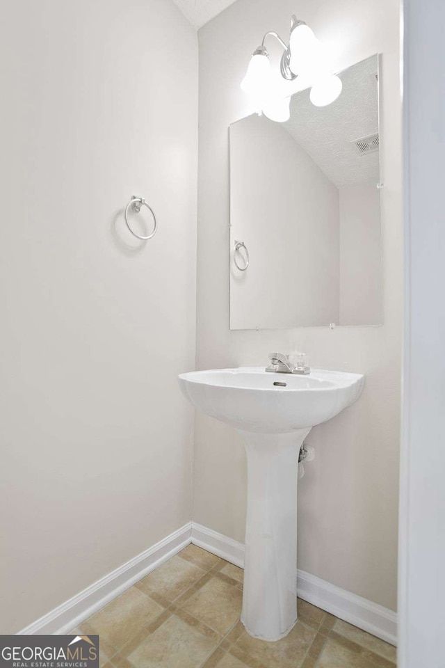 bathroom with baseboards and visible vents