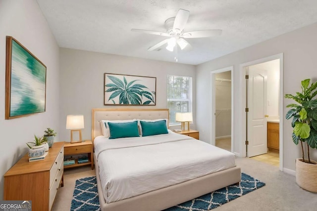bedroom with a spacious closet, baseboards, ceiling fan, light carpet, and a closet