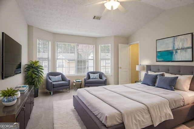 carpeted bedroom with vaulted ceiling, visible vents, ceiling fan, and a textured ceiling