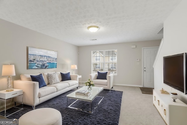 living area featuring light carpet, baseboards, and a textured ceiling