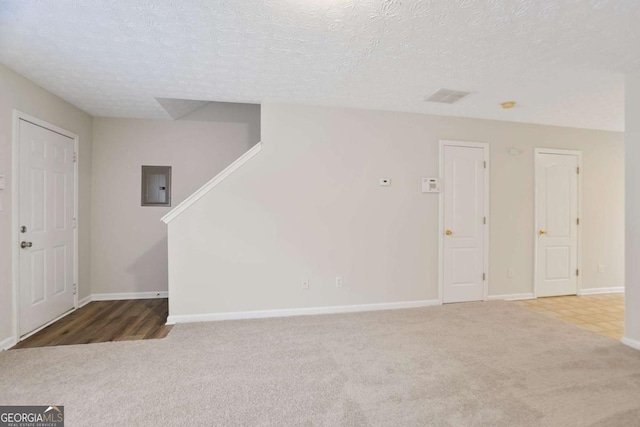 interior space with stairway, carpet floors, a textured ceiling, and electric panel