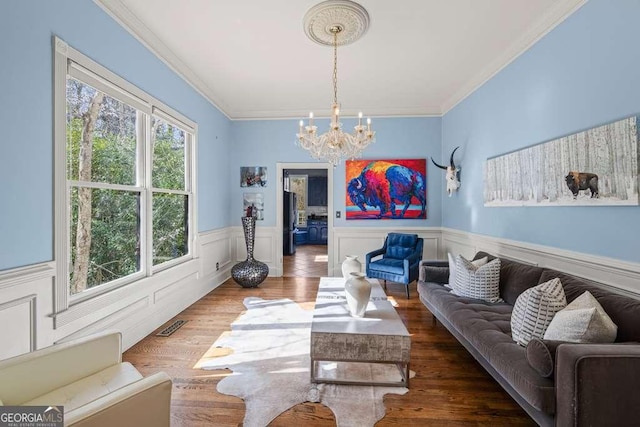 1768 Hood Rd, Dacula, GA 30019 - living room with a chandelier, ornamental molding, a wainscoted wall, and wood finished floors