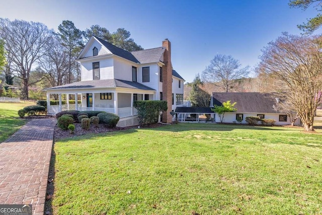 1768 Hood Rd, Dacula, GA 30019 - view of front of house featuring a porch, a chimney, a front yard, and a shingled roof