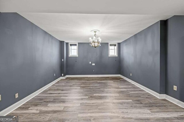1768 Hood Rd, Dacula, GA 30019 - unfurnished dining area with wood finished floors, a chandelier, and baseboards