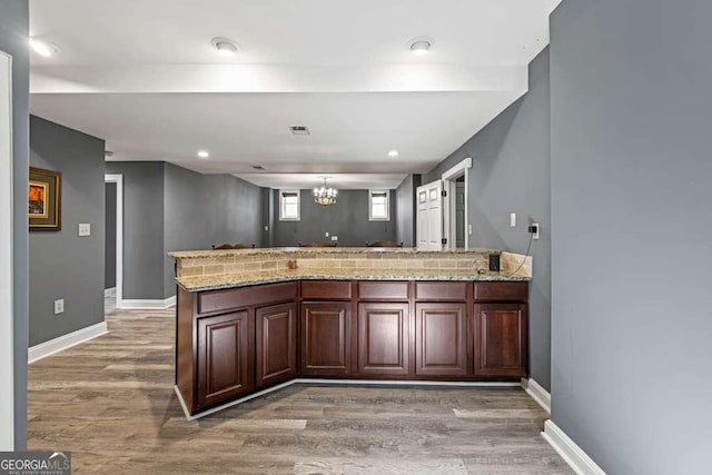 1768 Hood Rd, Dacula, GA 30019 - kitchen featuring light wood-style flooring, a chandelier, light stone countertops, and baseboards