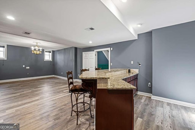 1768 Hood Rd, Dacula, GA 30019 - kitchen with wood finished floors, a kitchen breakfast bar, baseboards, light stone countertops, and recessed lighting