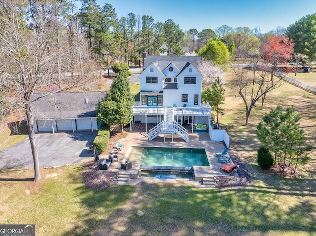 1768 Hood Rd, Dacula, GA 30019 - rear view of house featuring stairs, a lawn, an outdoor pool, a garage, and a balcony
