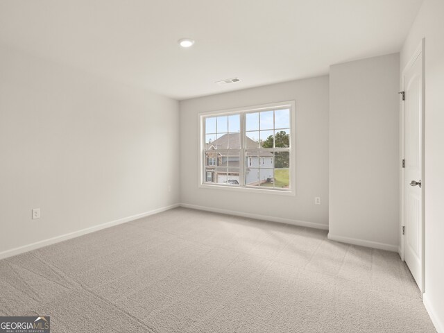 spare room with light carpet, baseboards, and visible vents