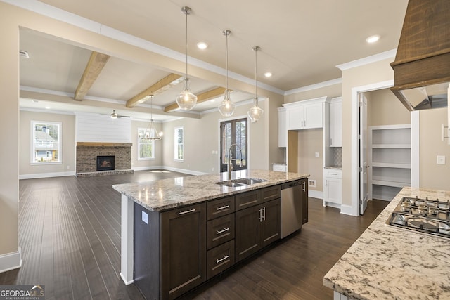 kitchen featuring a sink, a fireplace, appliances with stainless steel finishes, dark wood-style floors, and white cabinets