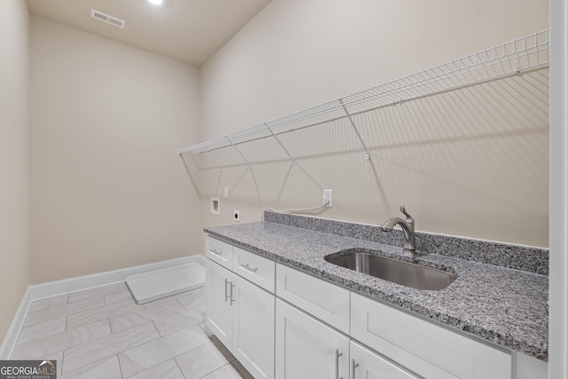 laundry area featuring hookup for an electric dryer, a sink, visible vents, cabinet space, and washer hookup