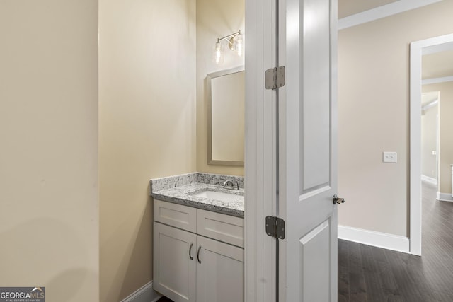 bathroom featuring vanity, baseboards, and wood finished floors