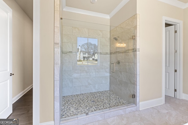 full bath featuring baseboards, crown molding, a shower stall, and wood finished floors