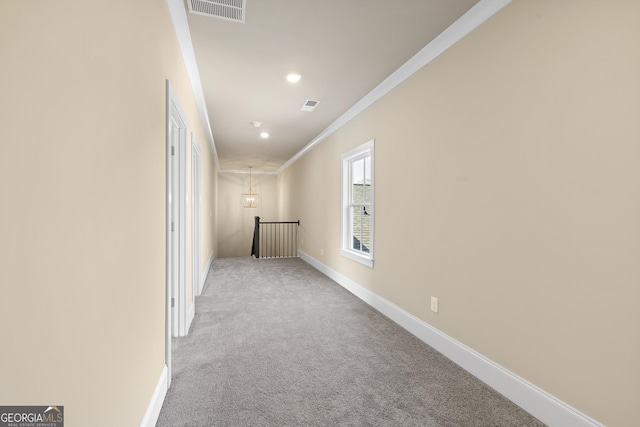 hallway featuring an upstairs landing, crown molding, carpet flooring, baseboards, and visible vents