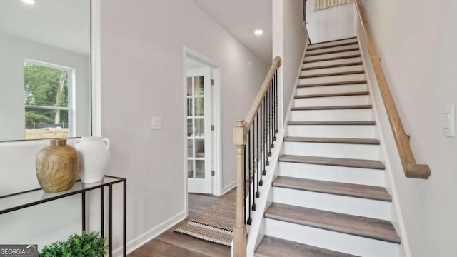 staircase featuring baseboards, wood finished floors, and recessed lighting