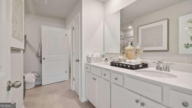 full bath with double vanity, tile patterned flooring, and a sink