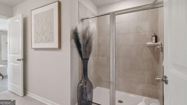 full bathroom featuring a stall shower and baseboards