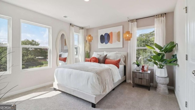 bedroom featuring light colored carpet and baseboards