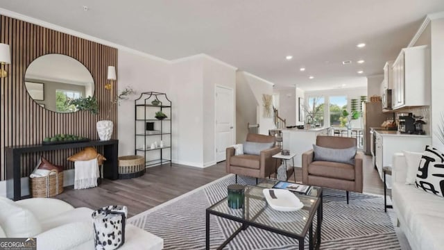 living area featuring baseboards, recessed lighting, wood finished floors, and ornamental molding