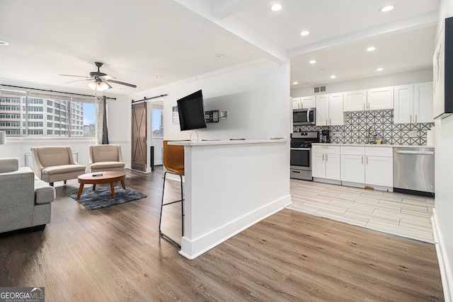 215 Piedmont Ave NE Unit 708, Atlanta, GA 30308 - kitchen featuring appliances with stainless steel finishes, a barn door, white cabinets, recessed lighting, and a ceiling fan