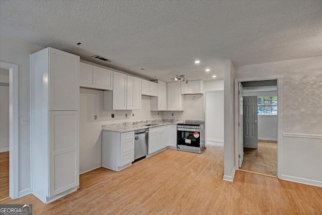 kitchen featuring stainless steel appliances, light wood-style floors, a textured ceiling, and white cabinets