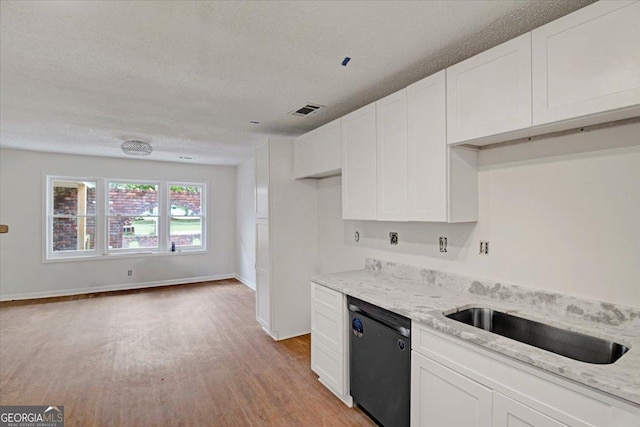 kitchen with light wood-style floors, dishwasher, visible vents, and a textured ceiling