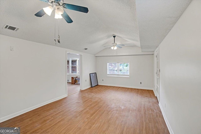 unfurnished living room featuring light wood-style floors, visible vents, a textured ceiling, and a ceiling fan