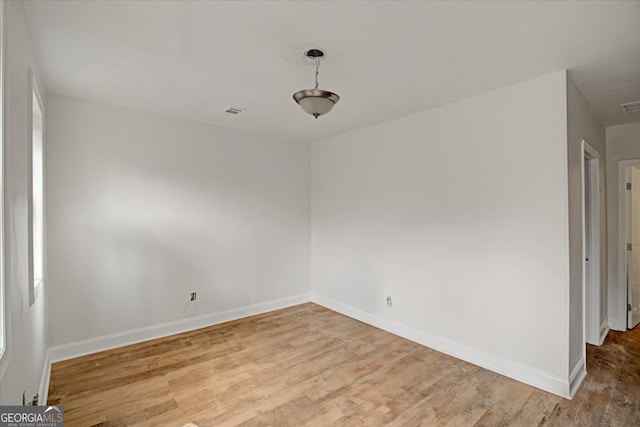 empty room with visible vents, baseboards, and wood finished floors