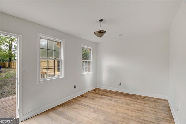 unfurnished dining area featuring visible vents, light wood-type flooring, and baseboards