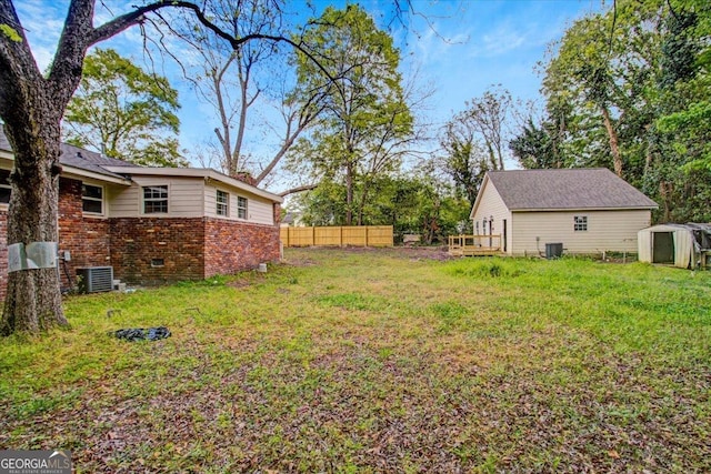 view of yard with a shed, cooling unit, an outdoor structure, and fence