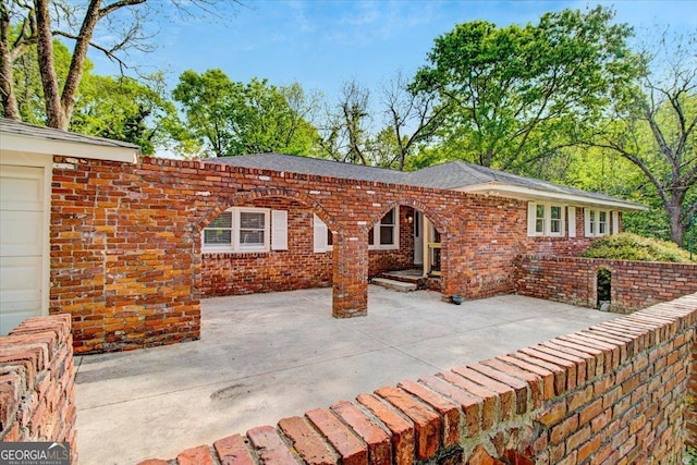 back of property featuring brick siding