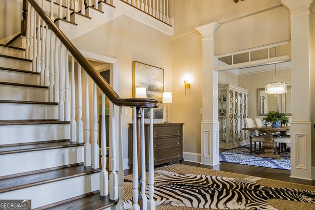 2 Palmer Dr NW, Rome, GA 30165 - staircase with a high ceiling, ornate columns, and wood finished floors