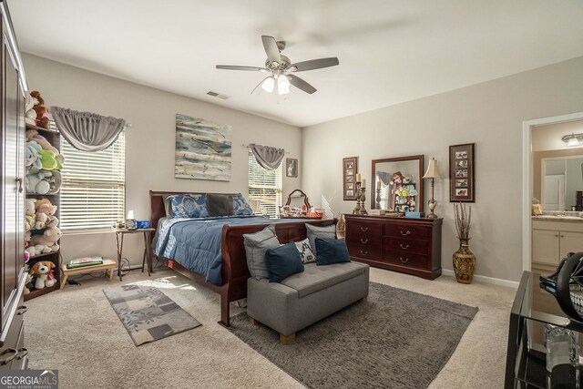 bedroom with connected bathroom, ceiling fan, light colored carpet, baseboards, and visible vents