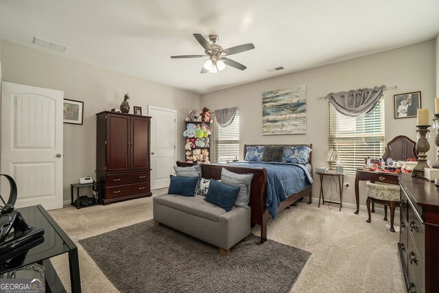 bedroom with visible vents, light carpet, and multiple windows