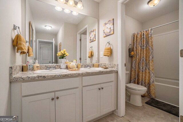 bathroom with a sink, shower / bath combo with shower curtain, toilet, and double vanity