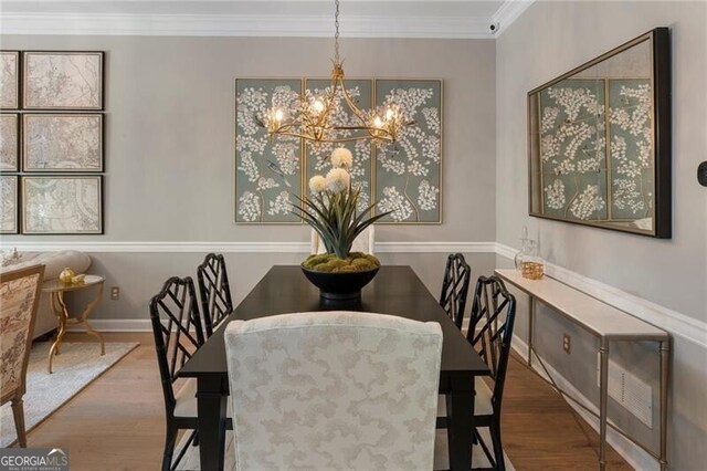 2630 Milford Ln, Alpharetta, GA 30009 - dining room with wood finished floors, a chandelier, and crown molding