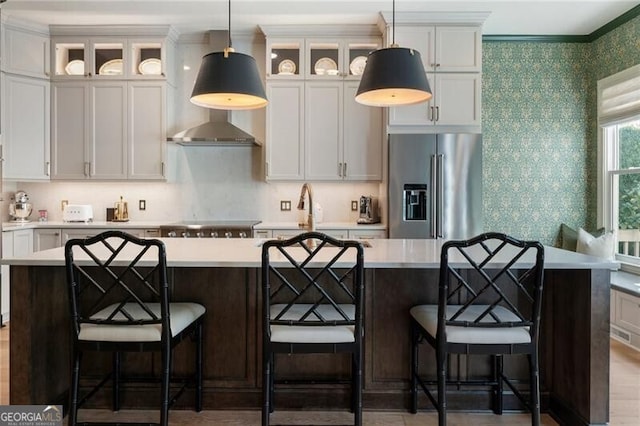 2630 Milford Ln, Alpharetta, GA 30009 - kitchen featuring high end fridge, light countertops, a center island with sink, wallpapered walls, and glass insert cabinets