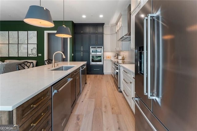 2630 Milford Ln, Alpharetta, GA 30009 - kitchen featuring high end appliances, light wood-style floors, light countertops, wall chimney exhaust hood, and white cabinetry