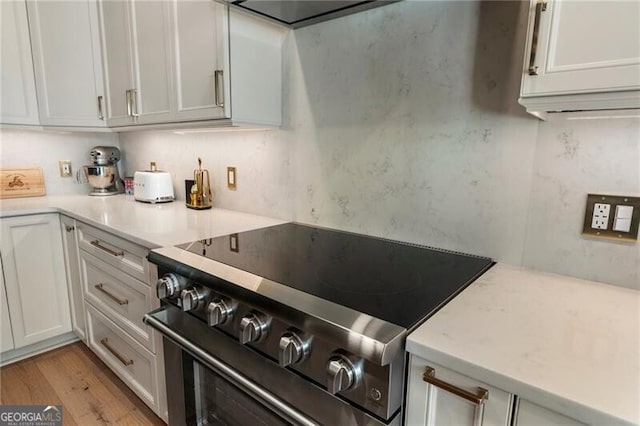 2630 Milford Ln, Alpharetta, GA 30009 - kitchen featuring stainless steel electric range oven, light countertops, light wood-style flooring, and white cabinetry