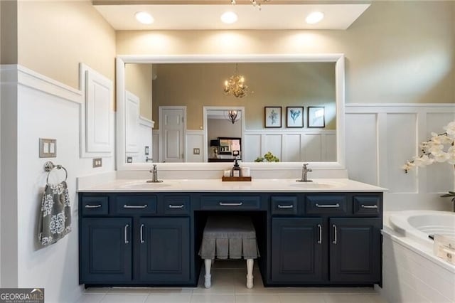 2630 Milford Ln, Alpharetta, GA 30009 - bathroom featuring double vanity, a decorative wall, a bath, a wainscoted wall, and a chandelier