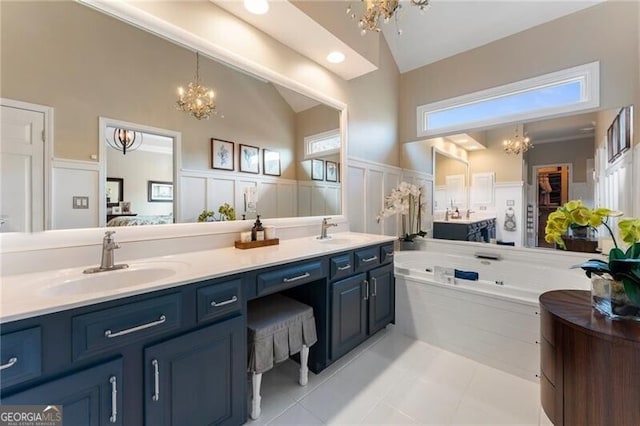 2630 Milford Ln, Alpharetta, GA 30009 - bathroom featuring a chandelier, double vanity, tile patterned flooring, a decorative wall, and a whirlpool tub