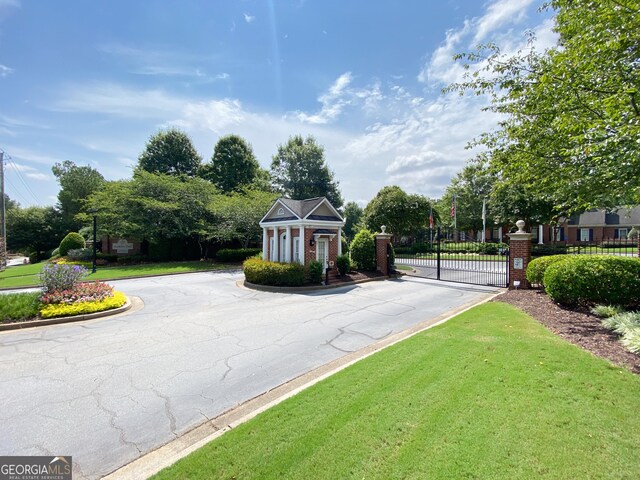 2630 Milford Ln, Alpharetta, GA 30009 - view of asphalt road with a gate, curbs, and a gated entry