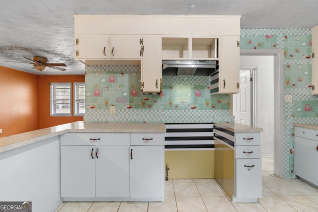 kitchen featuring light tile patterned floors, light countertops, a ceiling fan, white cabinetry, and under cabinet range hood